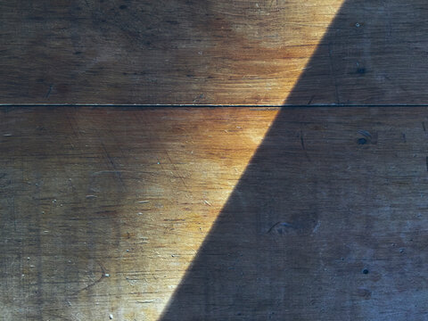 Shadow on worn wood table, close up