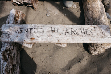 hand written note on driftwood at beach while camping