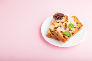 Homemade cake with raisins and dried persimmon on a pink pastel background. Side view, copy space.