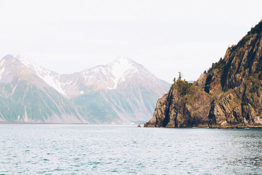 A Sheer Island Cliff Jutts Into The Ocean Waters Of Resurrection Bay Alaska