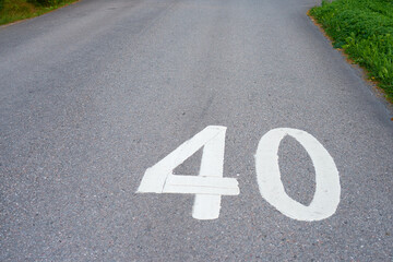 Inscription 40 on an asphalted road for the speed limit. Copy space.