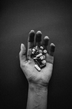 Hand of a young Woman holding a pills.