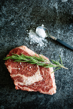 Rib eye steak with rosemary on a granite background.