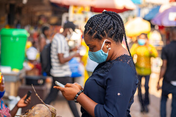image of Africa lady in face mask, hold smart phone- out door concept