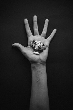 Hand of a young Woman holding a pills.