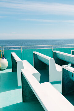 Empty White Benches Sit On Top Of An Aquamarine Sun Deck Of An Alaskan Cruise Ship