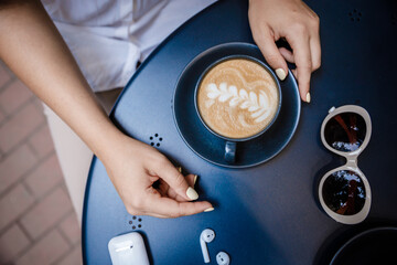 Cup of cappuccino with a pattern on a wooden bench.