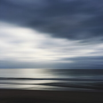 Late afternoon movement shot of the ocean on a calm day under a Winter Sky