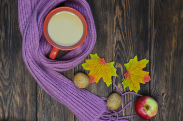 Warming cocoa in cold season, scarf, apples, autumn leaves, nuts. Concept decoration and celebration thanksgiving day