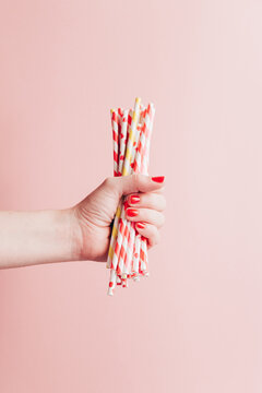 Hand holding striped straws