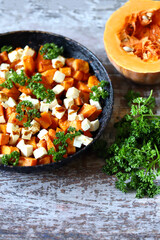Baked pumpkin with feta cheese in a frying pan. Healthy autumn food. Thanksgiving Day. Selective focus. Macro.