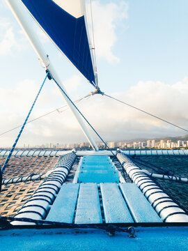 The Bow And Foremast Of A Catamaran Sailing Off The Coast Of Honolulu
