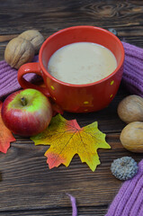 Warming cocoa in cold season, scarf, apples, autumn leaves, nuts. Concept decoration and celebration thanksgiving day