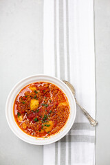 Top View of Vegan Vegetable Soup in a White Bowl on a Gray Countertop