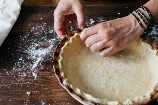 Woman's hands shaping a pie
