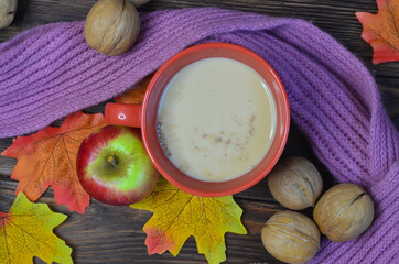 autumn drink coffee with milk and warm knitted scarf top view, walnuts, apples, strengthen the immune system in the cold season, healthy warming beverage