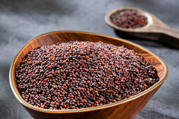 Black mustard seeds in wooden bowl - Brassica nigra