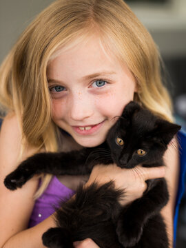 Happy Little Girl Holding Rescued Stray Kitten