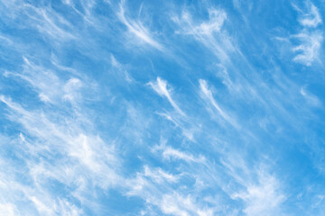 Blue sky and white cirrus clouds background. Amazing spindrift clouds. Natural cloudy backdrop.