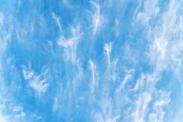 Blue sky and white cirrus clouds background. Beautiful spindrift clouds. Natural sky backdrop.