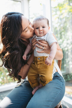 Young Mom Kissing Baby Inside