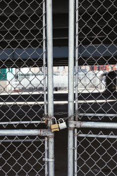 Fence door closed by two padlocks.