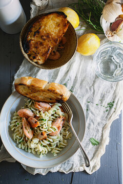 Seafood pasta dish on table with garlic bread.
