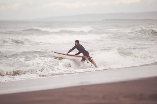 Surfer going into the water for a surf session