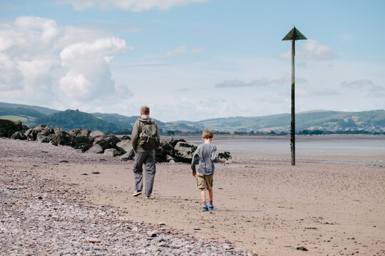 Father and son walking along the beach