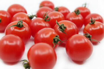 Cherry tomato branch. Cherry tomatoes isolated on a white background. Red tomatoes on a twig on a white background.