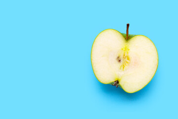 Fresh half green apple on blue background.