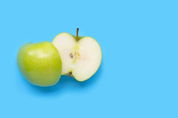 Fresh green apple on blue background.