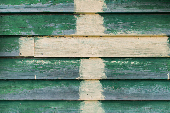 green siding with painted cross