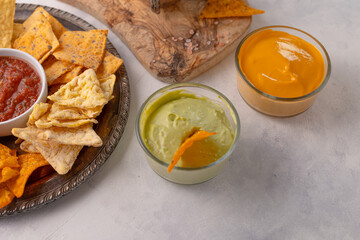 The side view of corn chips with avocado souse and cheese dip isolated on white background. Food concept.