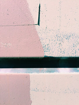 Detail of paint covering graffiti tags on metal wall