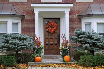 Front door with colorful fall wreath and pumpkins