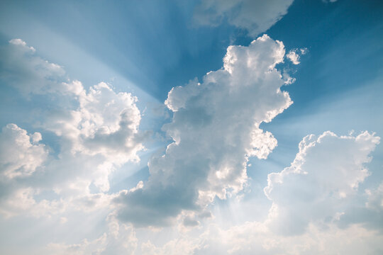 sun beams striking through beautiful blue cloudy sky