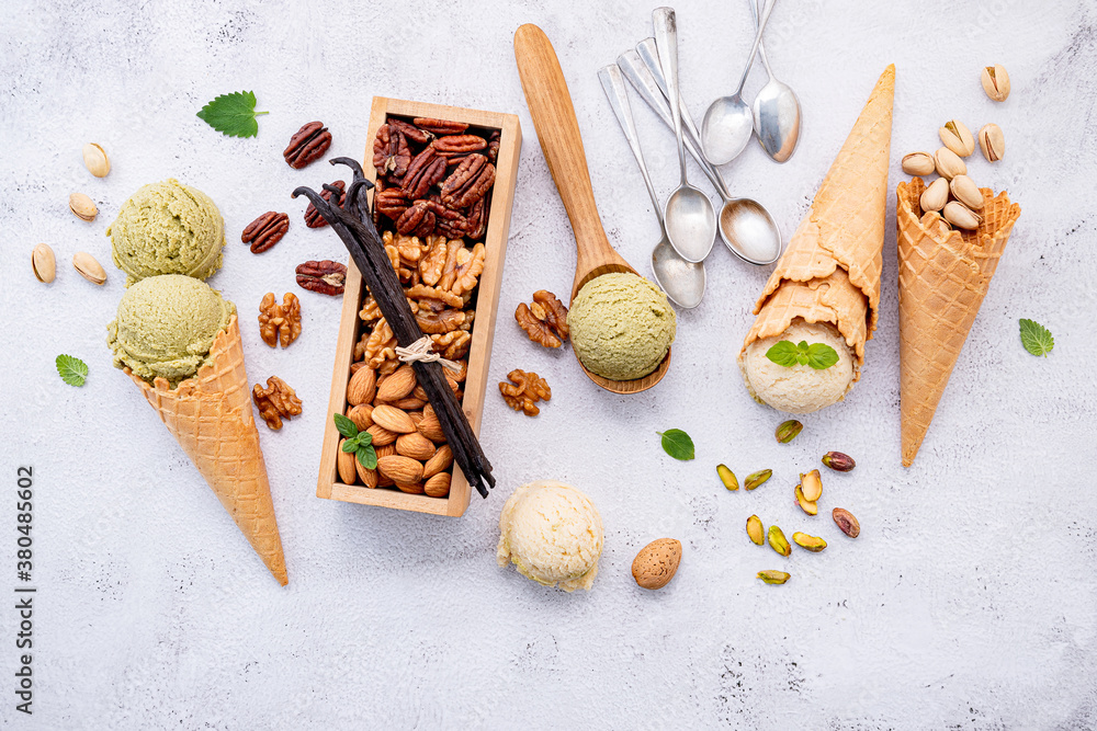 Poster pistachio and vanilla ice cream in cones with mixed nut setup on white stone background . summer and