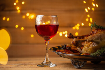 The glass of red wine for Christmas dinner isolated on wooden background. Festive image. Holiday concept. Close-up.