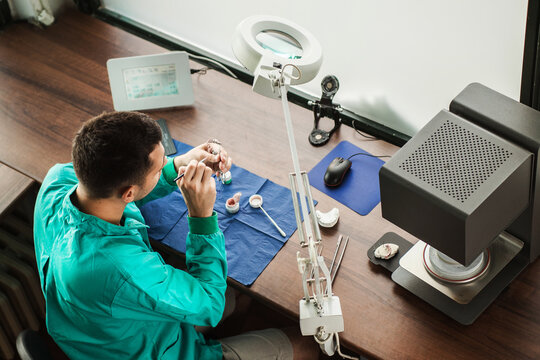 Look from above on dental technician working on dentures in his ordination.