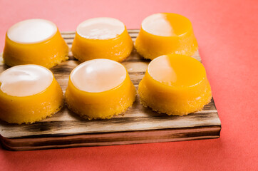 Delicious Quindins on wooden board, traditional Brazilian dessert made with egg yolk, sugar and coconut.