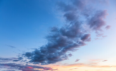 Beautiful View of Puffy Colorful Clouds with blue Sky in Background during a sunny summer sunrise. Taken in Yukon, Canada.