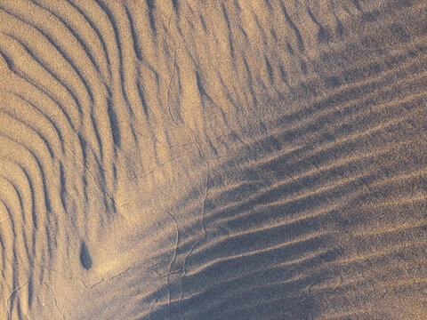 Patterns on beach sand at dusk, close up