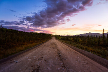 View of Scenic Road leading to Tombstone at Sunrise in Canadian Nature. Dempster Highway, Yukon, Canada.