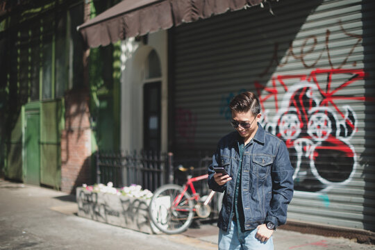 Young man checking cell phone in the city