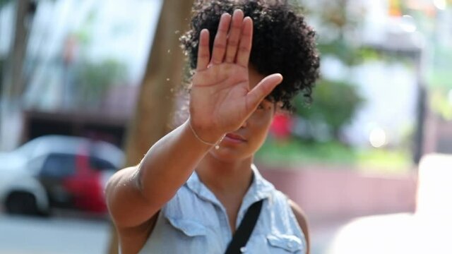 Young woman raising arm saying telling to stop