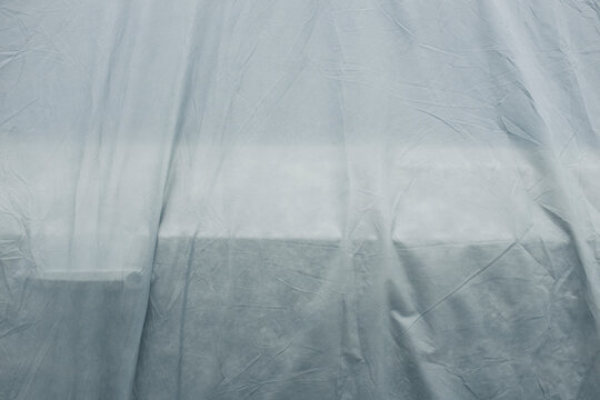 Grey protective fabric covering car, close up