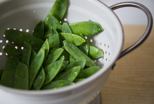 Fresh mange tout sitting in a colander