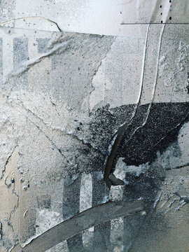 Close up of silver and metallic paint covering graffiti tags on urban wall