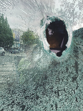 Hole in broken shattered glass window
